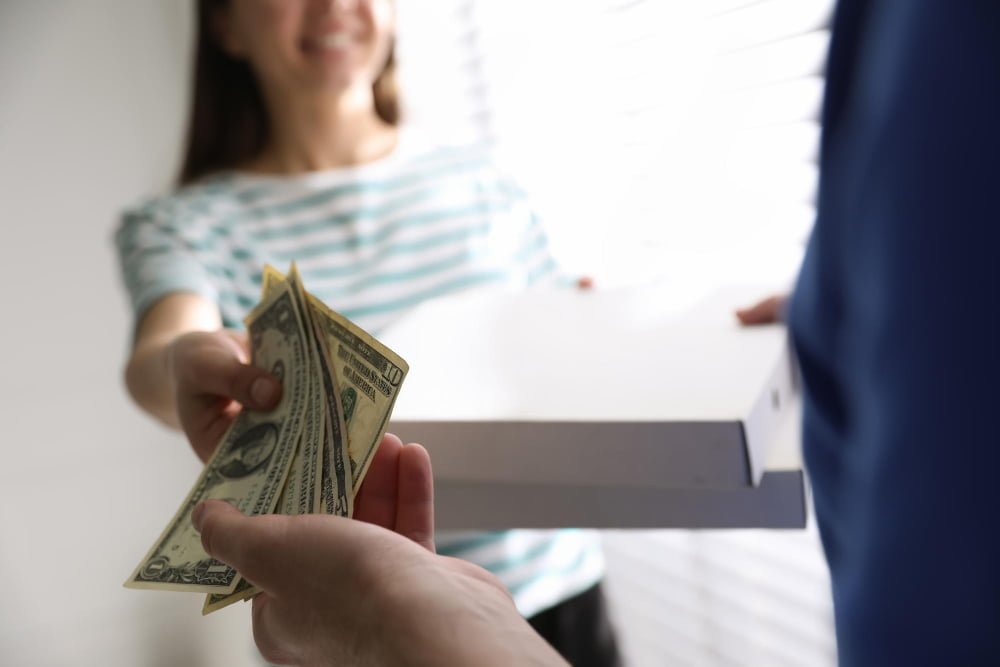 lady giving tips to worker