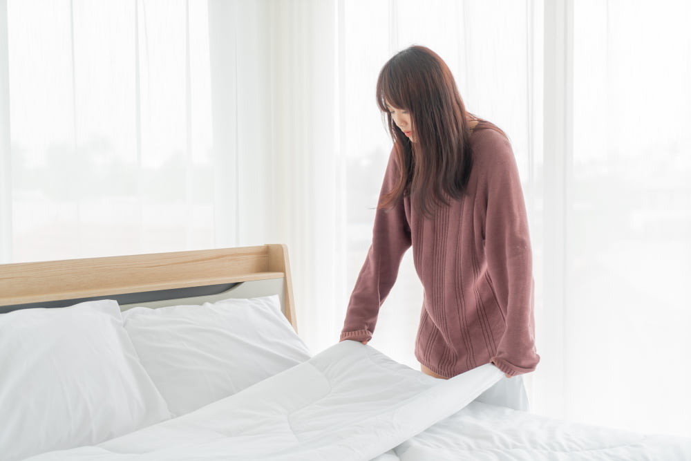 woman cleaning bedding